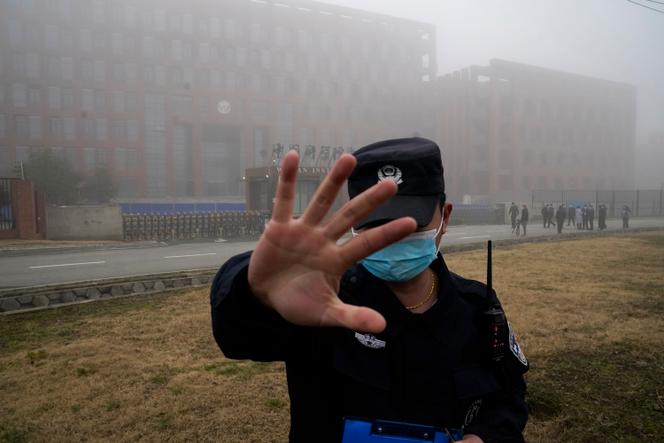 Un membre de la sécurité éloigne les journalistes de l’Institut de virologie de Wuhan après l’arrivée d’une équipe de l’Organisation mondiale de la santé pour une visite sur le terrain à Wuhan, dans la province du Hubei, en Chine, le 3 février 2021.