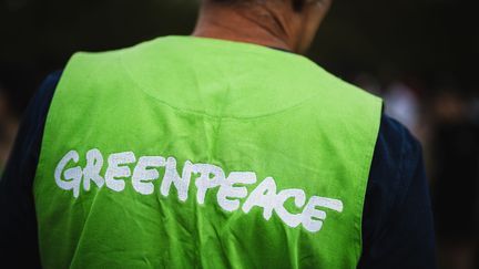 Un militant de Greenpeace lors d'une manifestation, à Paris, le 26 août 2023