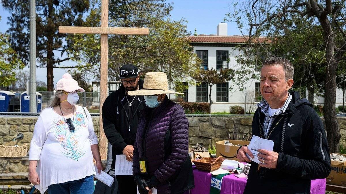 Les membres de l’église écoutent une prière durant la procession