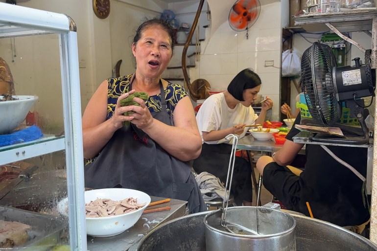 Shamshau préparant un grand pot de phở avec un sourire chaleureux