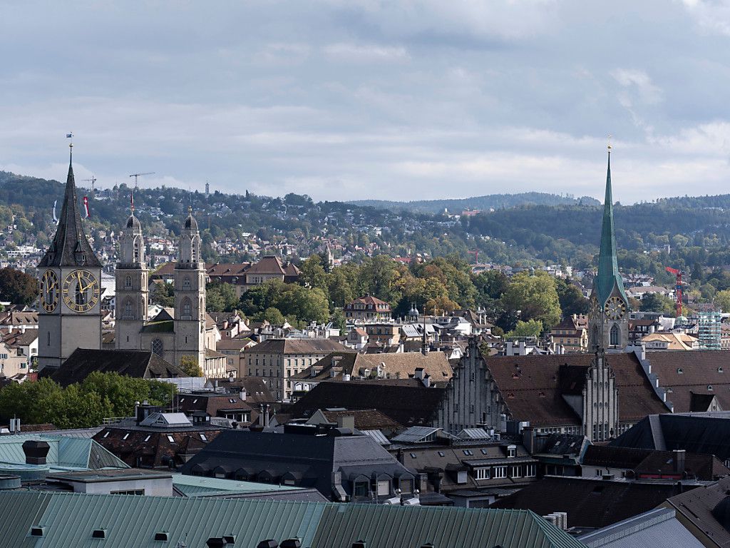 Vue de la skyline de Zurich avec églises et espaces verts en arrière-plan, illustrant les thématiques religieuses en Suisse.