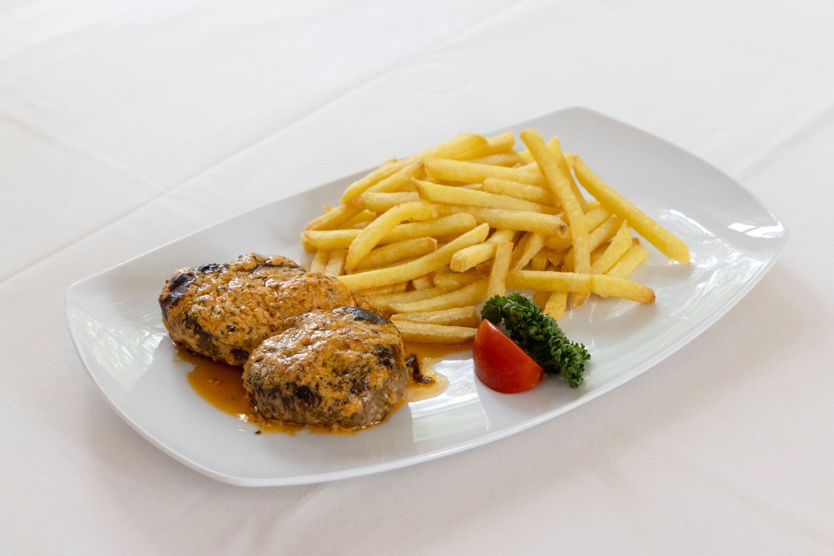 Boulettes de viande avec sauce café de Paris et frites au restaurant Muggenbühl, Zürich.