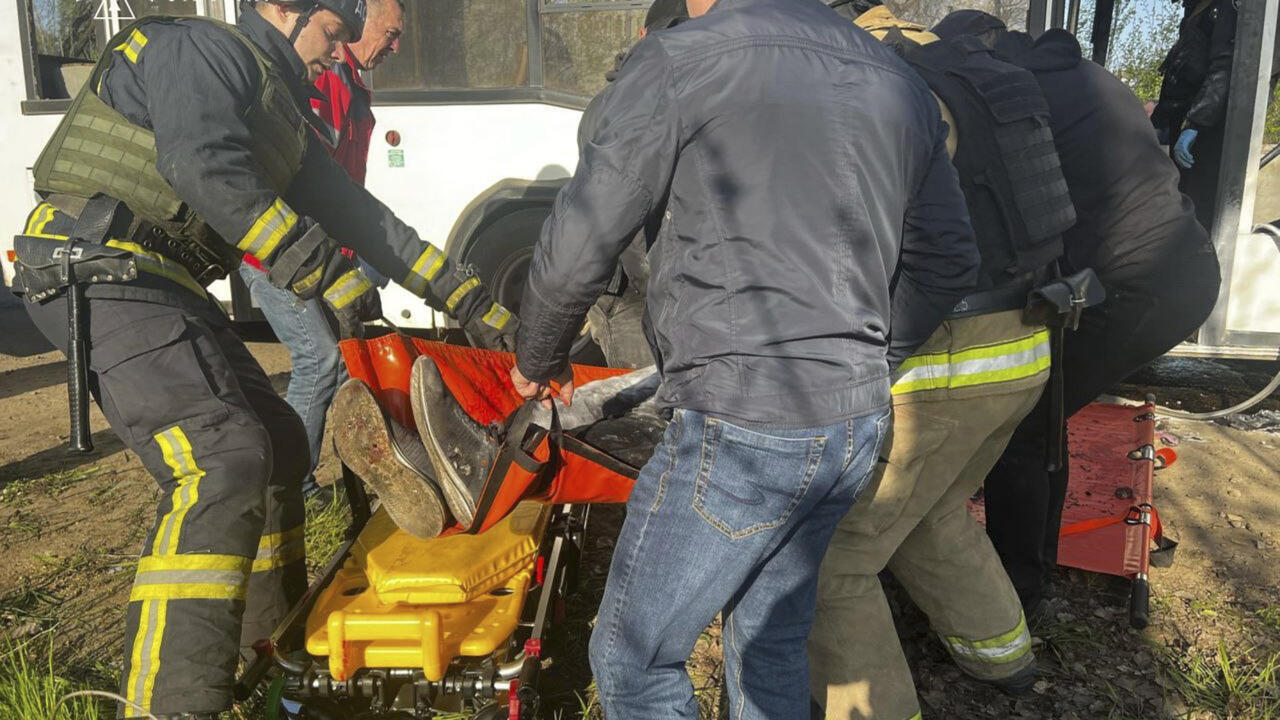 Secouristes transportant les corps des passagers après une attaque au drone russe sur un autobus à Marganets