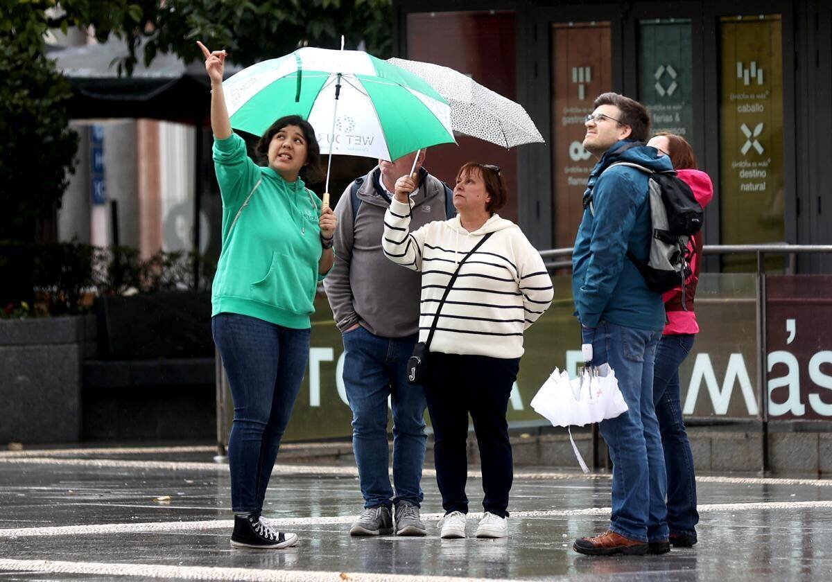 Guide touristique sous la pluie montrant Córdoba à un groupe de visiteurs en mars