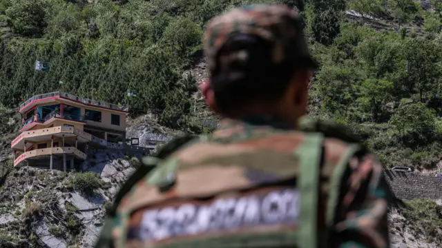 Vue du drapeau pakistanais et bâtiments depuis un village côté indien près de la ligne de contrôle au Cachemire