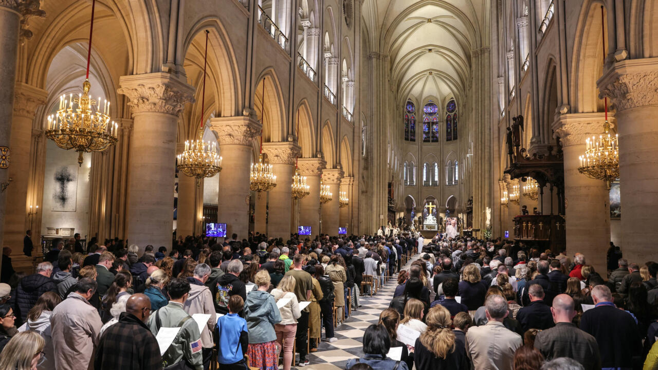 Des fidèles assistent à une messe solennelle à Notre-Dame de Paris pour le pape François
