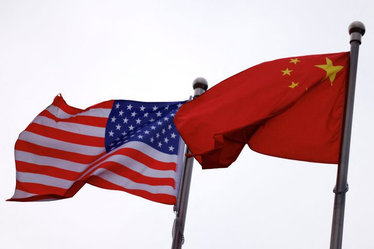 Drapeaux chinois et américains flottant devant une entreprise américaine à Beijing