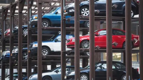 Parking mécanique à plusieurs niveaux avec voitures empilées verticalement dans une structure métallique
