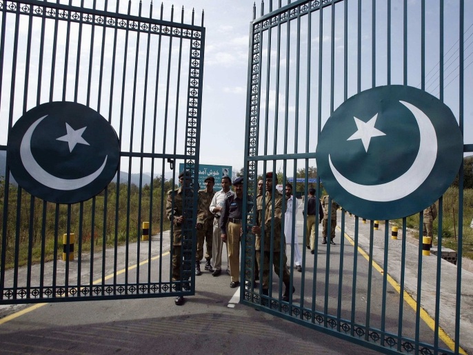 Agents pakistanais fermant une porte sur la ligne de contrôle entre Inde et Pakistan