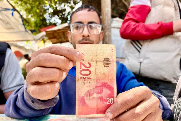 Abdo Abu Alwan en train de réparer des billets de banque endommagés à Gaza
