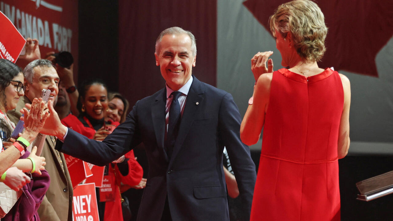 Le Premier ministre canadien Mark Carney et son épouse Diana Fox Carney saluent des partisans lors d'une fête de victoire à Ottawa, 29 avril 2025