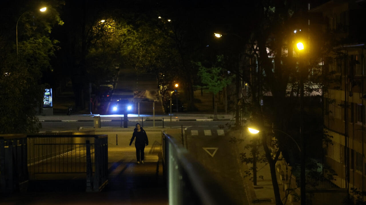 Une femme dans une rue obscure pendant une coupure d'électricité massive touchant toute la péninsule ibérique et le sud de la France, le 28 avril 2025 à Madrid, en Espagne