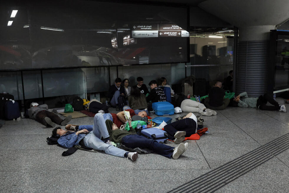 Des voyageurs se préparent à passer la nuit à la gare d'Atocha pendant une coupure d'électricité massive touchant toute la péninsule ibérique et le sud de la France, le 28 avril 2025 à Madrid, en Espagne