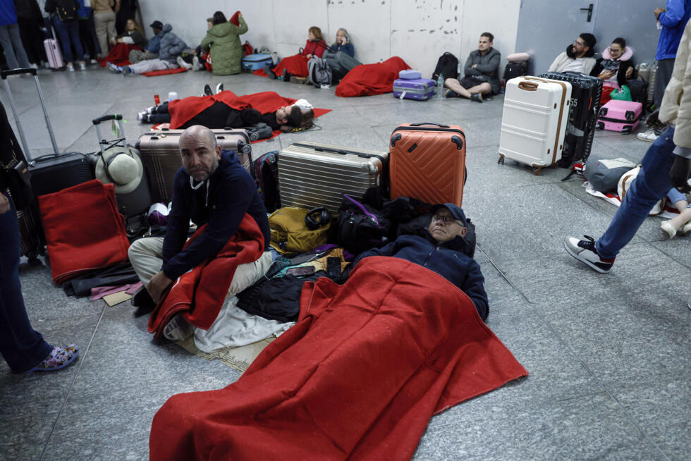 Des voyageurs se préparent à passer la nuit à la gare d'Atocha pendant une coupure d'électricité massive touchant toute la péninsule ibérique et le sud de la France, le 28 avril 2025 à Madrid, en Espagne