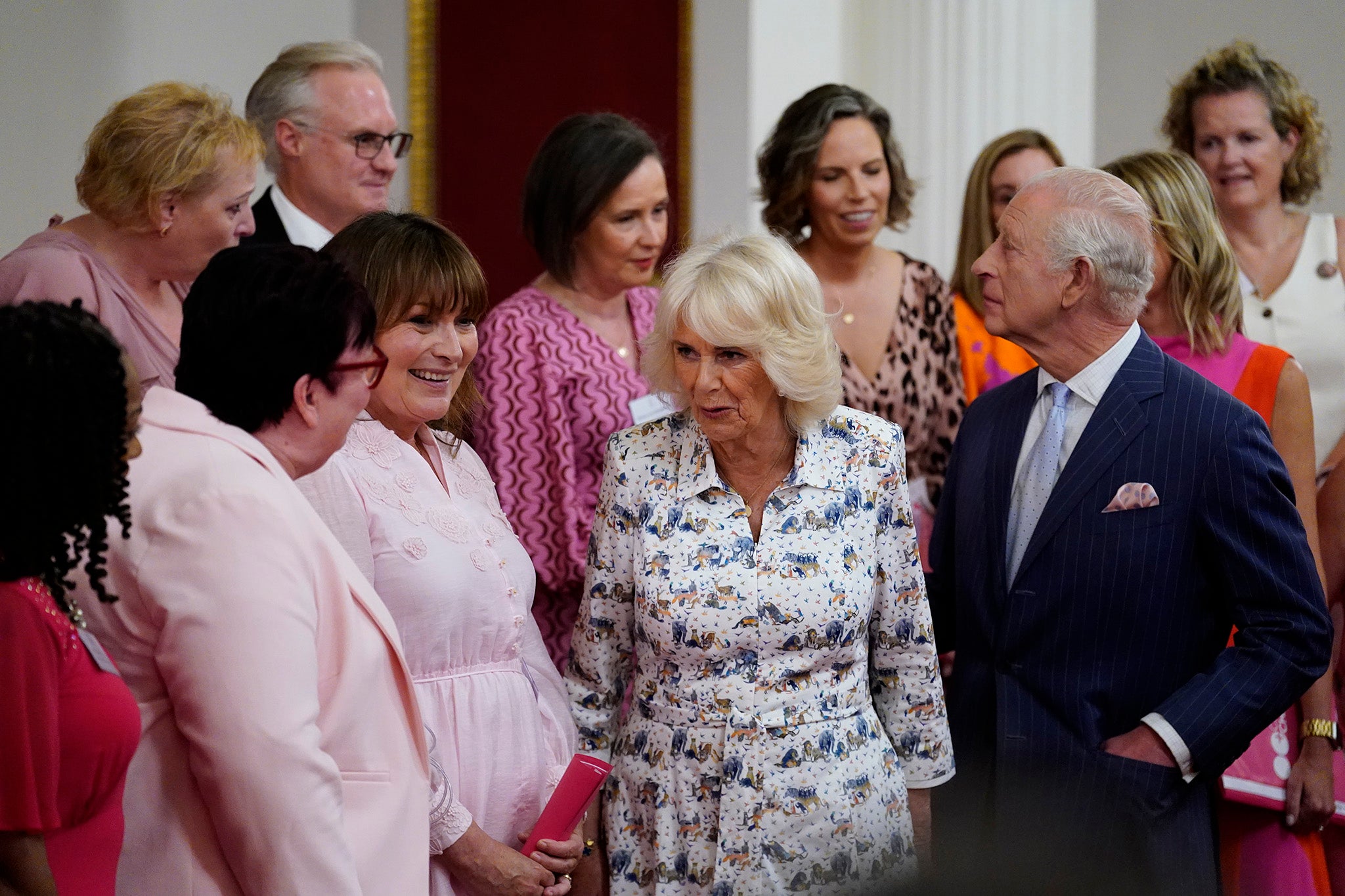 Charles et Camilla discutent avec la présentatrice Lorraine Kelly et les membres du Change + Check Choir lors d'une réception à Buckingham Palace