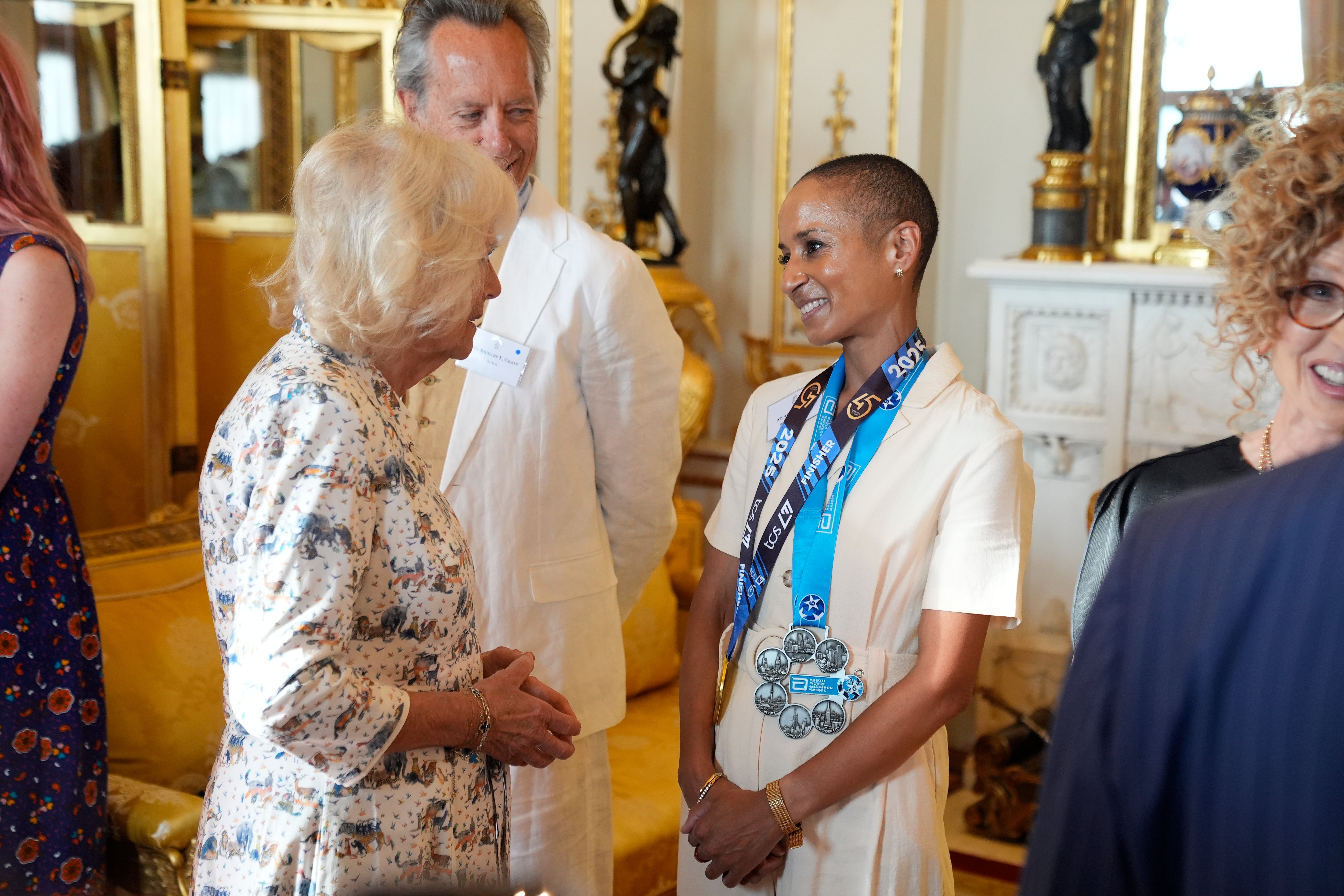 La reine Camilla discute avec la présentatrice Adele Roberts, portant ses médailles du marathon