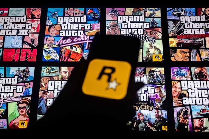 Le logo de Rockstar Games sur l’écran d’un smartphone et des couvertures de la série de jeux vidéo « Grand Theft Auto », à New York, le 27 novembre 2023.