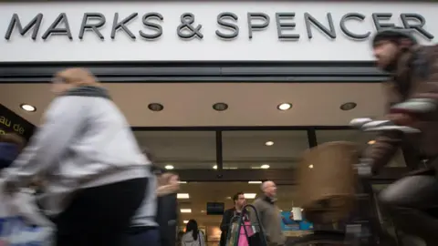 Personnes passant devant un magasin Marks & Spencer