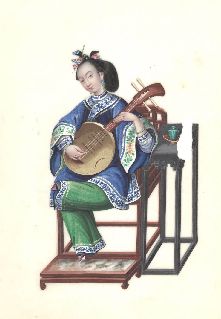 Une femme en tenue traditionnelle asiatique joue du pipa assise sur une chaise, avec une table à côté d’elle.