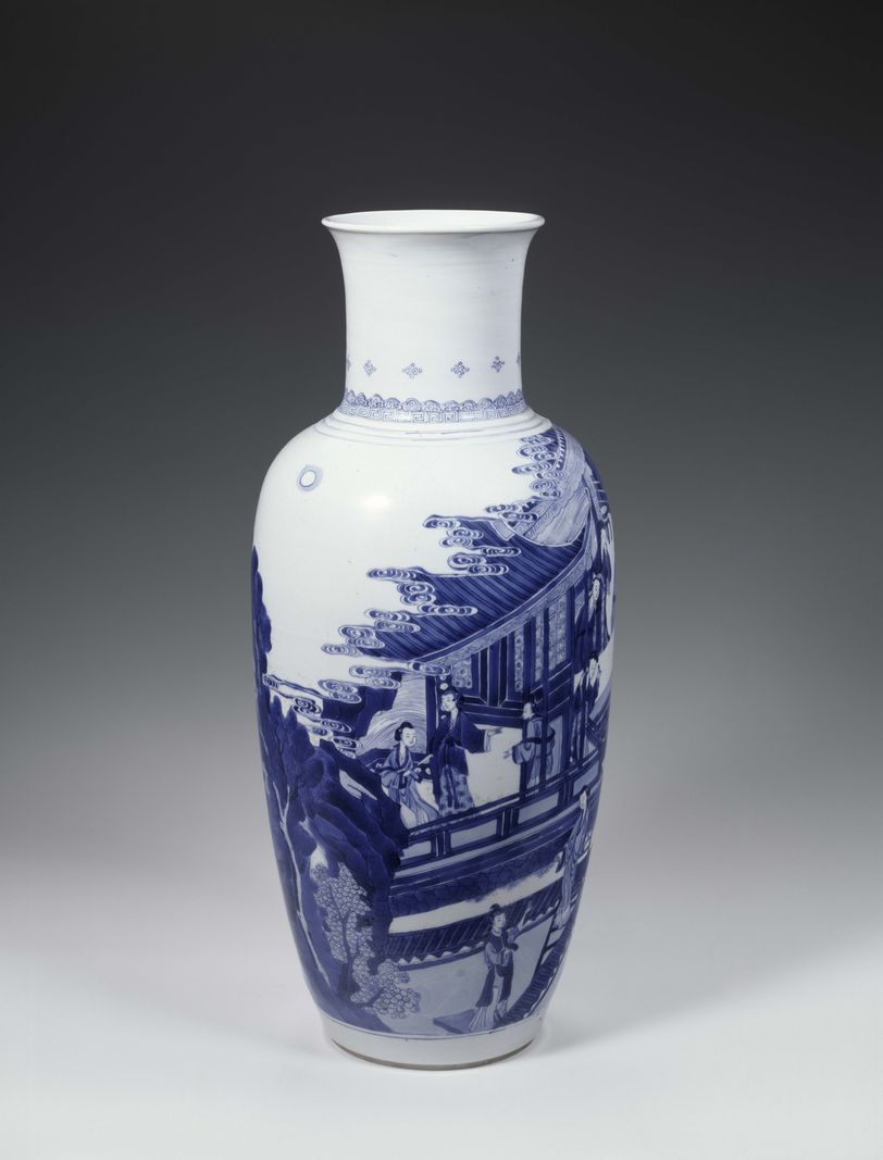 Vase en porcelaine blanche avec des motifs bleus représentant une scène architecturale asiatique traditionnelle, sur fond gris.