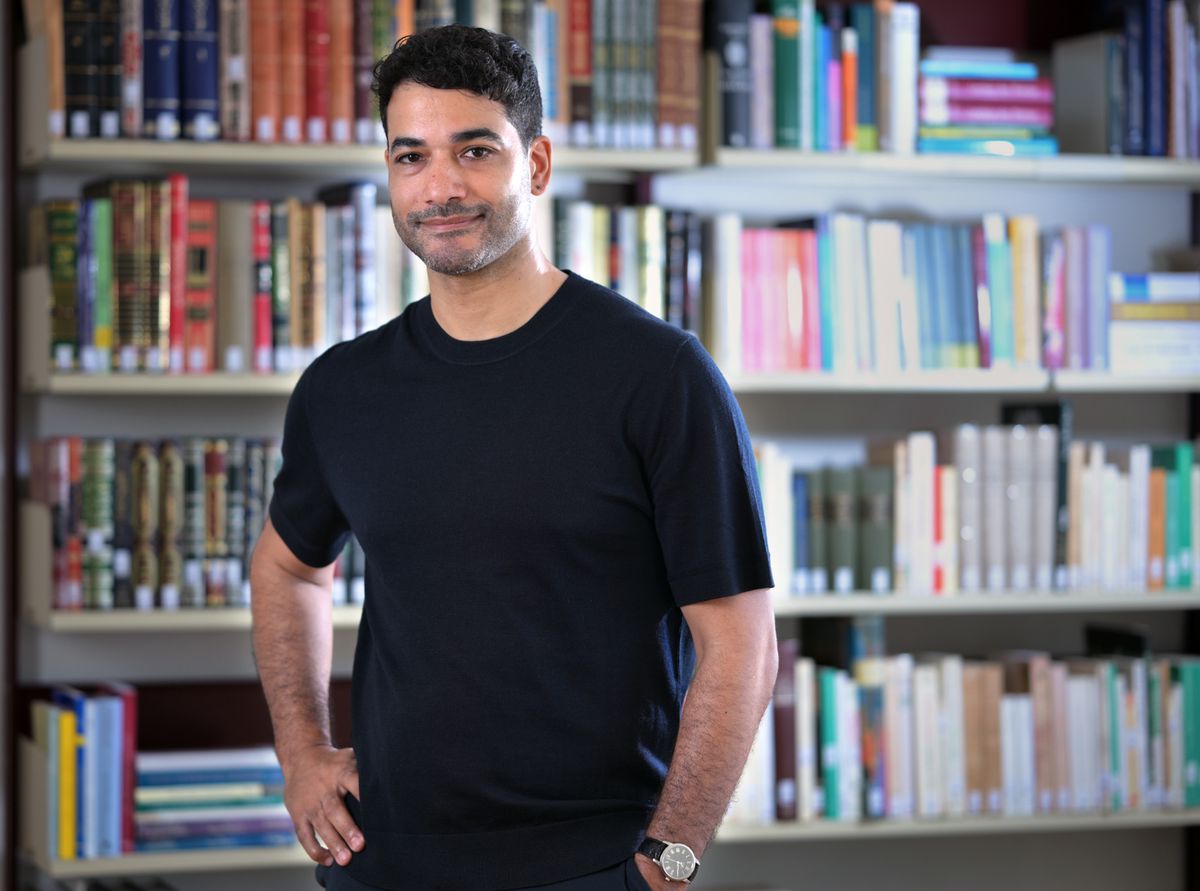 Professeur Dr Amir Dziri, co-directeur du Centre Islam et société de Fribourg, devant une étagère de livres à l’université de Fribourg.