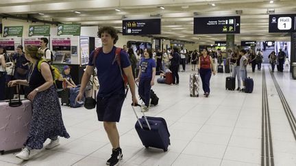 À la gare du Nord à Paris, les voyageurs descendent de leur train et font la queue devant les distributeurs automatiques de tickets pour accéder au réseau francilien, le 1er mai 2025. (ERIC BRONCARD / HANS LUCAS / AFP)