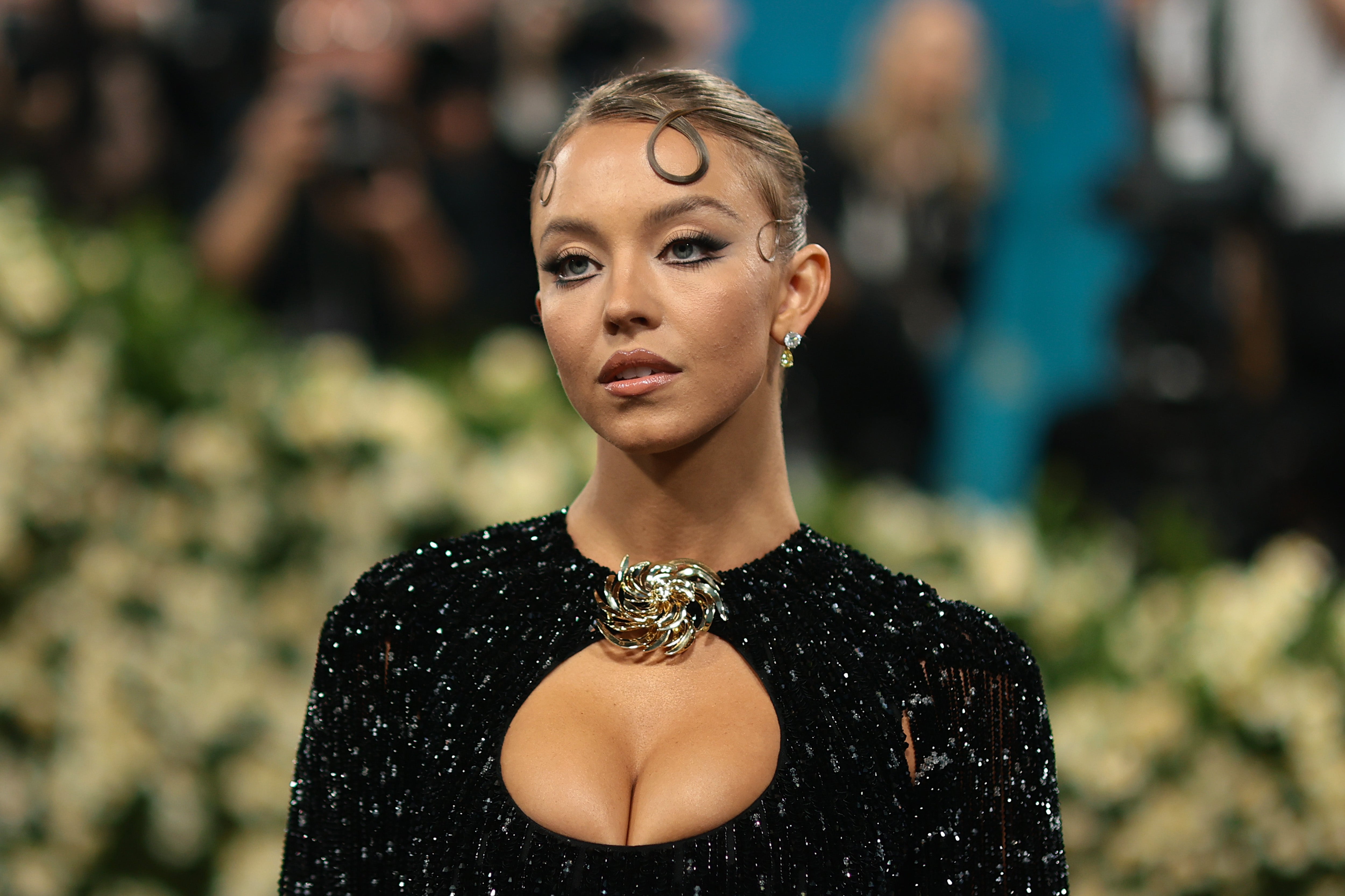 Sydney Sweeney avec un eye-liner graphique et robe noire