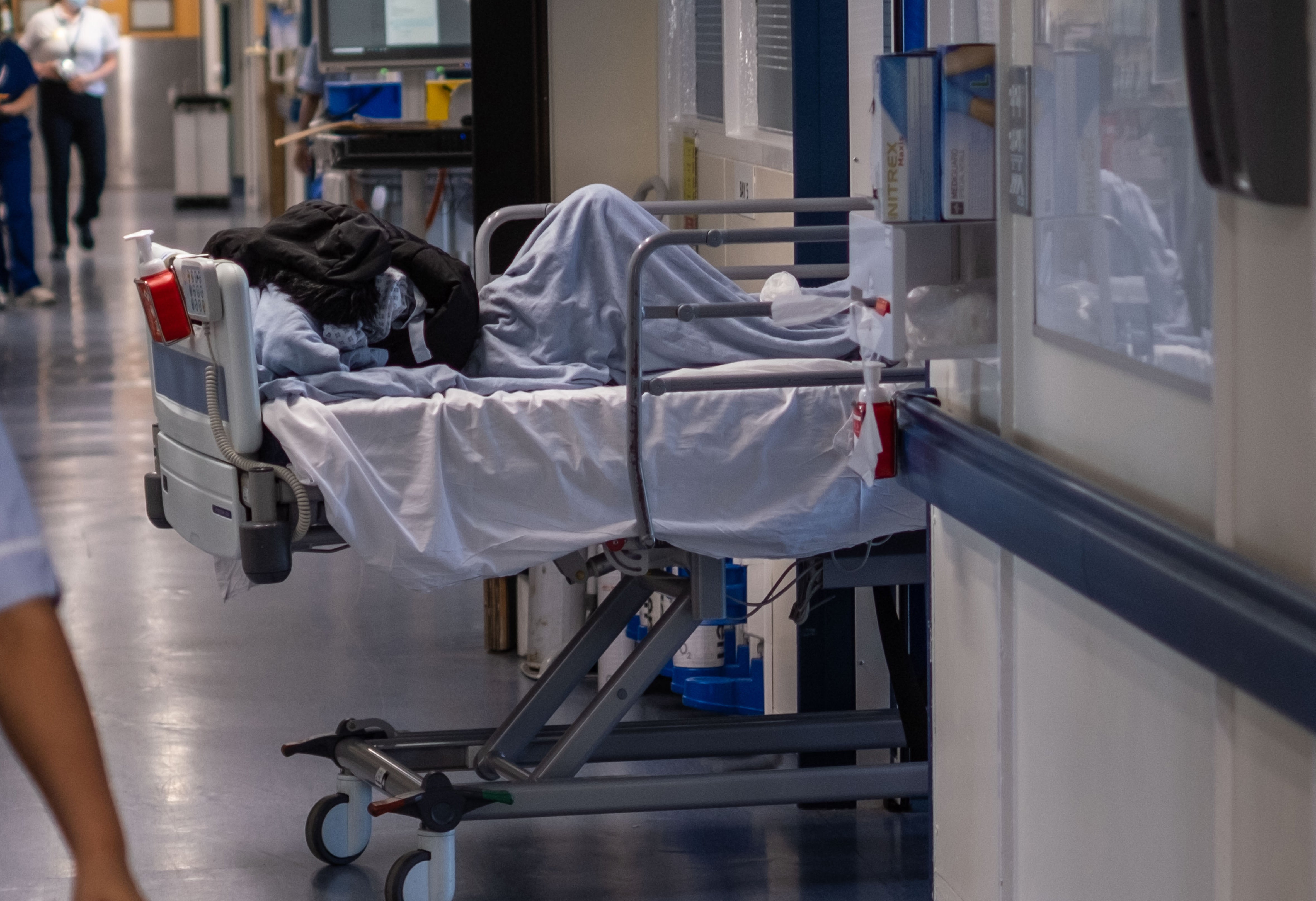 Nombreuses personnes âgées attendent sur des lits dans les couloirs des urgences