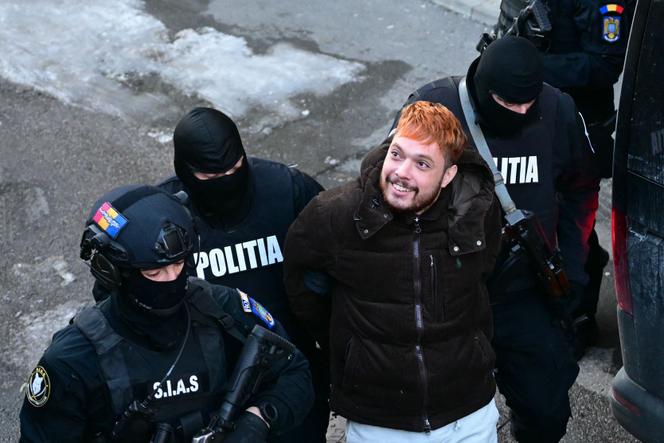Mohamed Amra est escorté par des policiers à Bucarest le 23 février 2025, au lendemain de son arrestation en vertu d’un mandat d’arrêt européen.