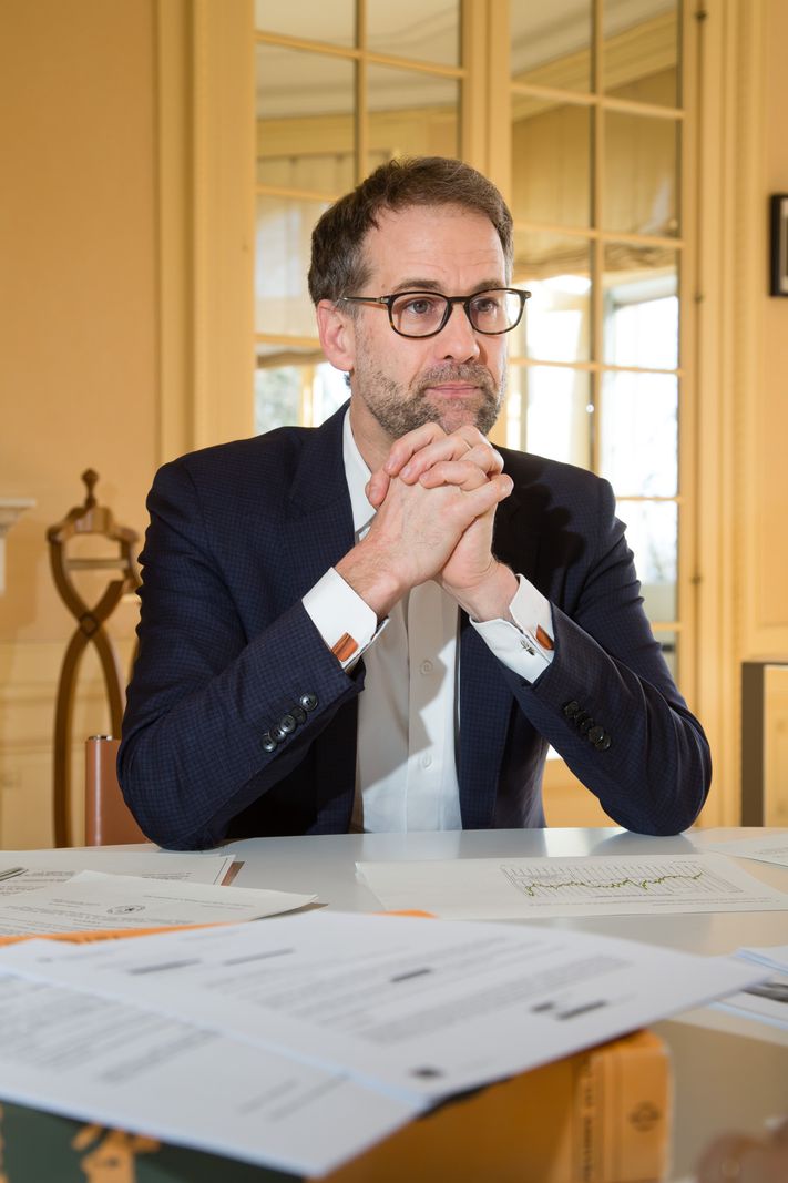 Antonio Hodgers, conseiller d’État, interviewé dans son bureau à Genève, le 5 mars 2025, assis à une table avec des documents.