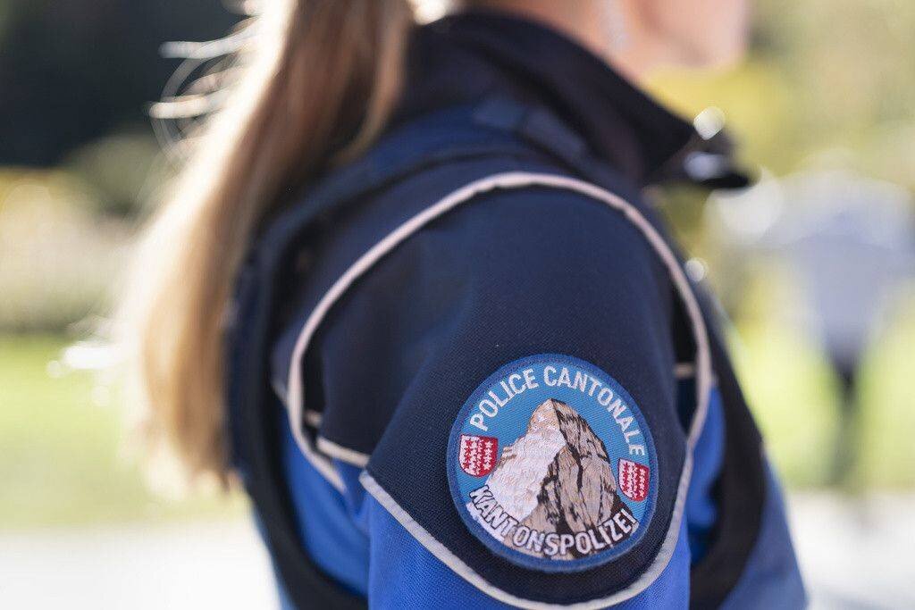 Une policière de la police cantonale valaisanne, prise en photo le 27 octobre 2021 à Raron, portant un uniforme bleu avec un écusson distinctif.