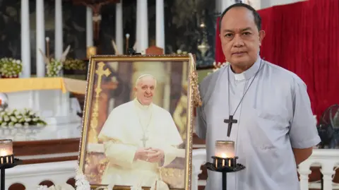 Cardinal Pablo Virgilio David près d'une photo du pape François dans une cathédrale