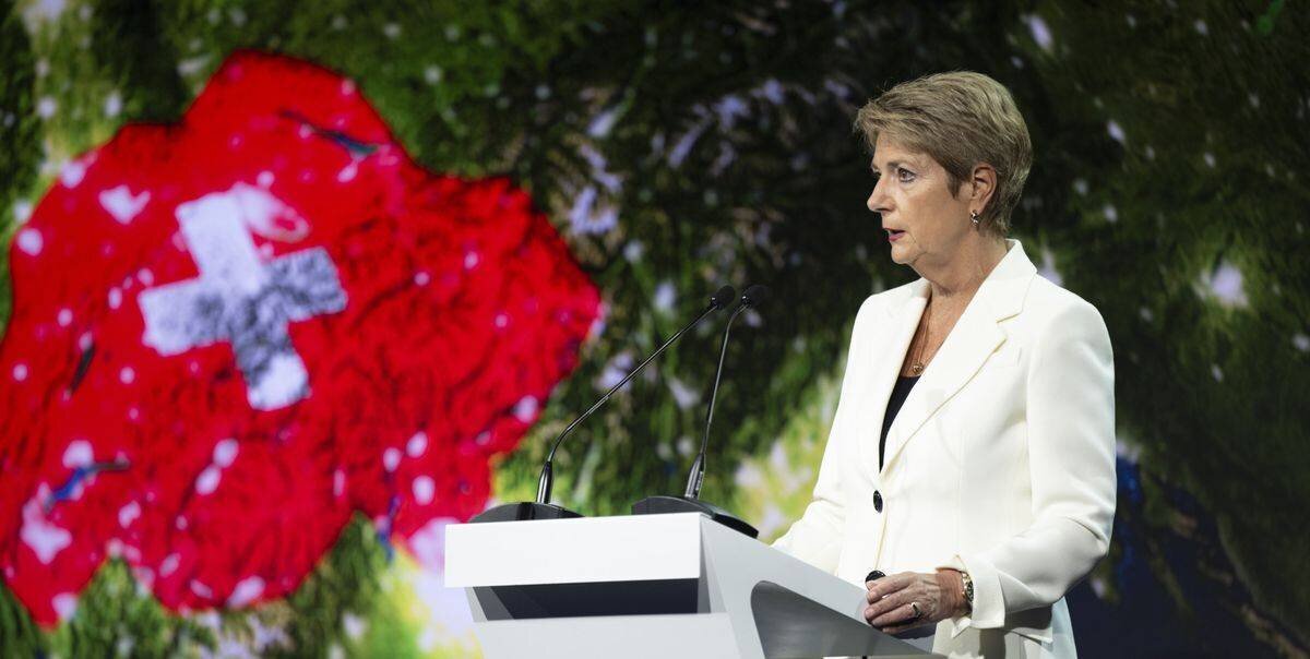 La présidente suisse Karin Keller-Sutter au Symposium de Saint-Gall 2025, avec le drapeau suisse en arrière-plan