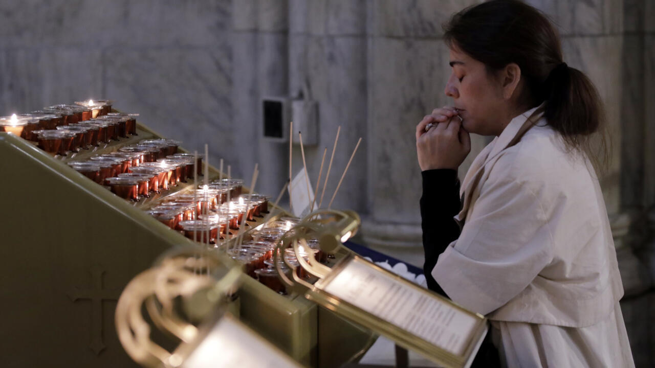 Une femme prie dans la cathédrale Saint Patrick à New York après l'élection du pape Léon XIV, le 8 mai 2025.