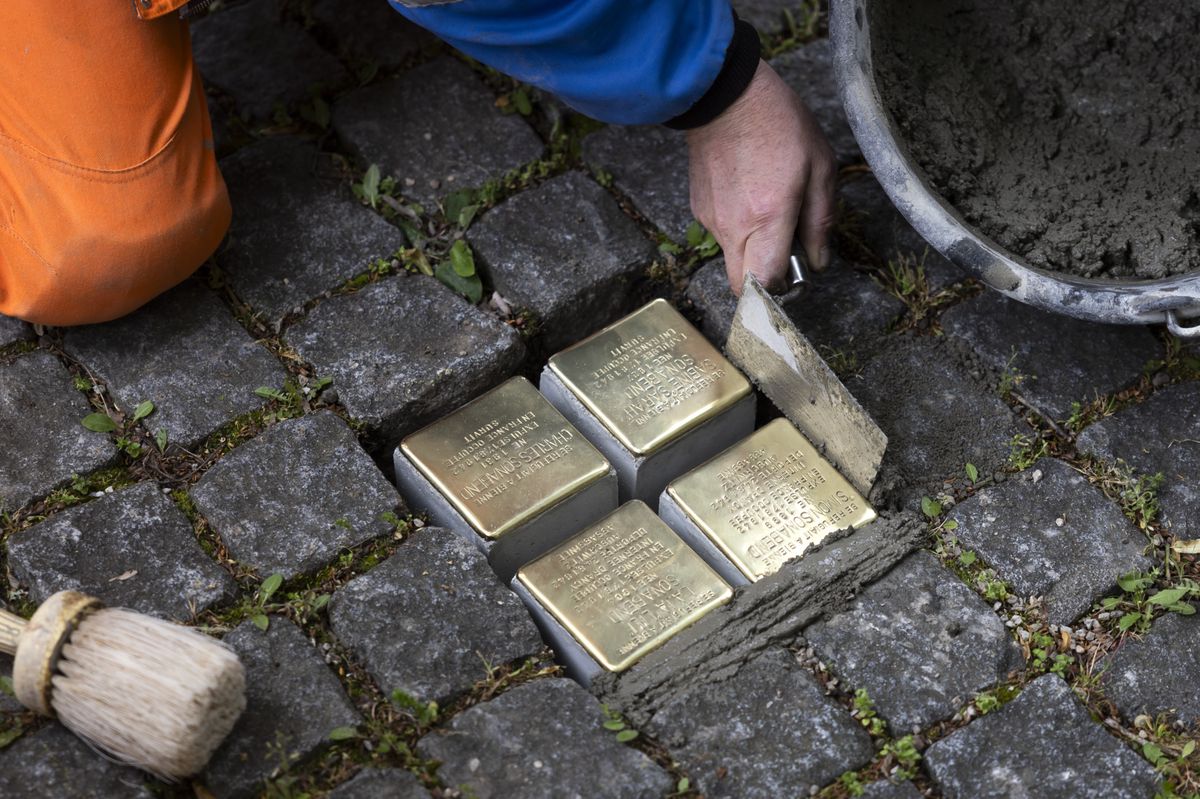 Un employé de la voirie de la ville de Bienne pose quatre Stolpersteine en mémoire de la famille Sonabend sur le chemin Mon-Désir à Bienne, le 8 mai 2025.