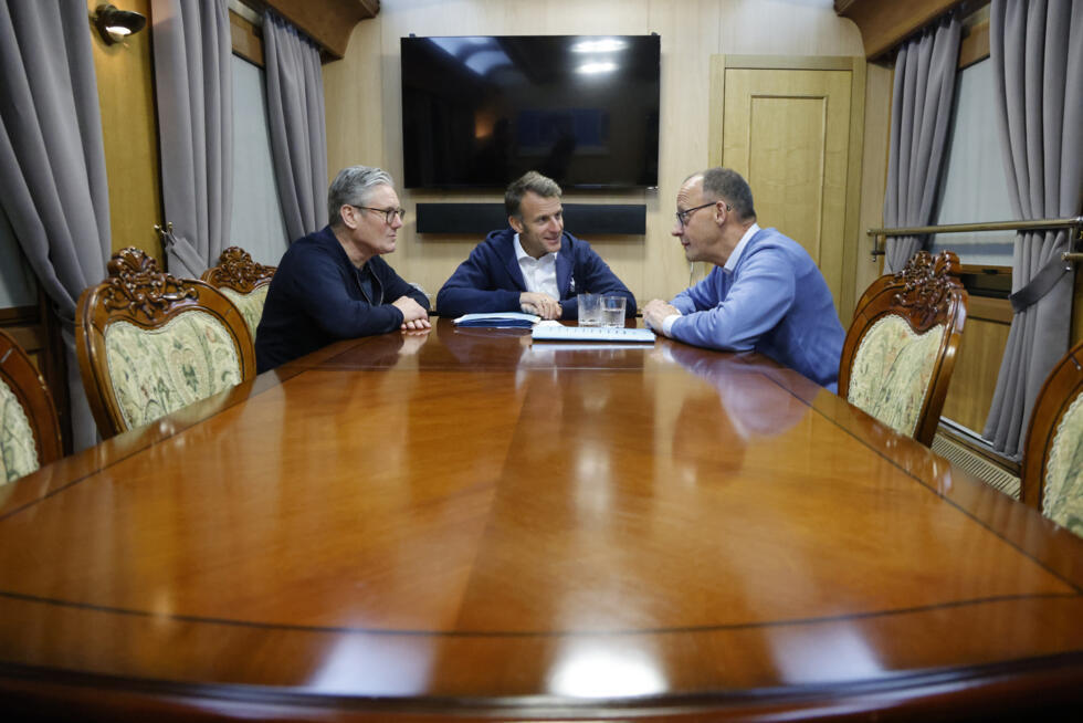Emmanuel Macron entouré de Keir Starmer (gauche) et Friedrich Merz (droite) lors d'une réunion trilatérale à bord d'un train pour l'Ukraine, le 9 mai 2025
