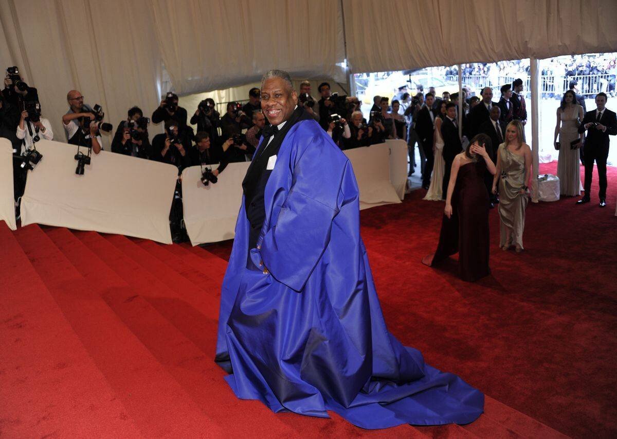 André Leon Talley portant une cape bleue volumineuse sur le tapis rouge lors du gala du Met au Metropolitan Museum of Art en 2011, entouré de photographes.
