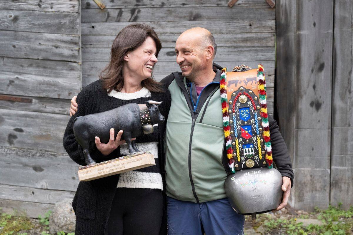 À Vollèges, Nathalie Terretaz et Jean-Philippe Terrettaz, éleveurs, posent avec leurs trophées de 2022, y compris une statuette de vache et un grand cloche décoré.