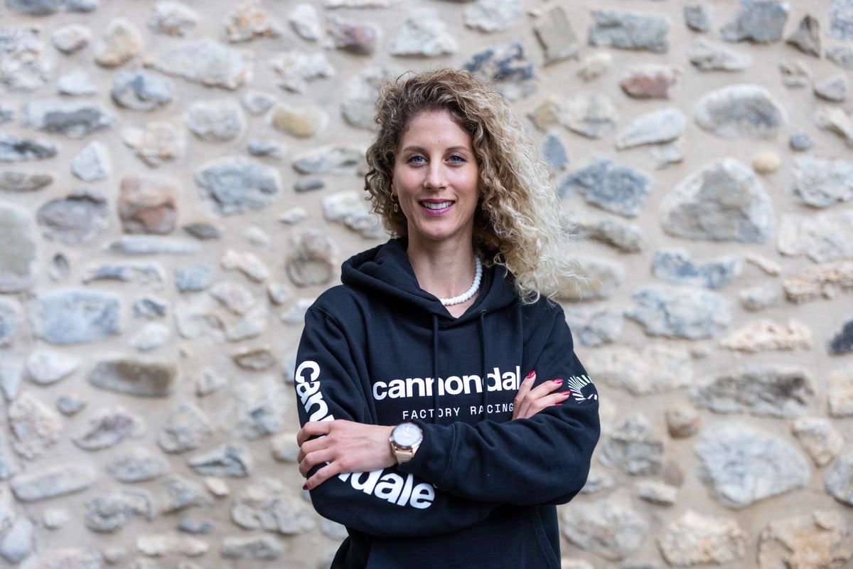 Jolanda Neff devant un mur en pierre, portant un pull Cannondale