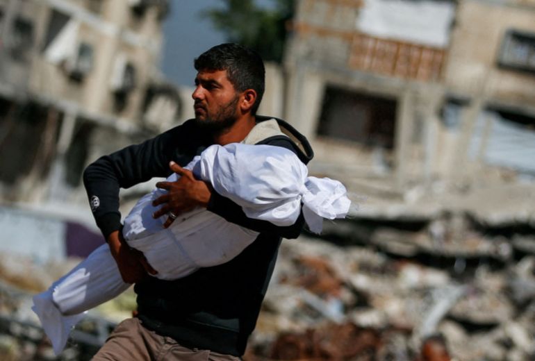Un Palestinien porte le corps d'un enfant tué lors des bombardements à Jabalia, nord de Gaza