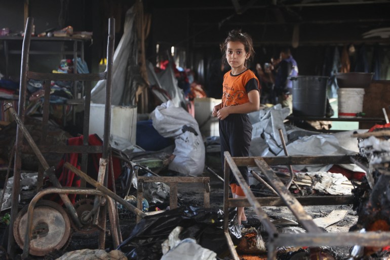 Une fille palestinienne cherche des objets récupérables parmi les débris après la frappe aérienne israélienne à l'école Moussa bin Nuseir à Gaza