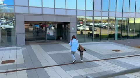 Corinna et sa fille de trois ans entrant à la prison de Five Wells