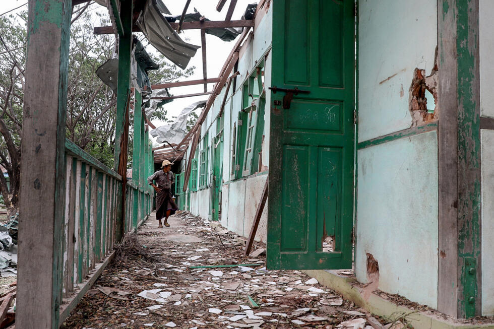Un homme inspecte un bâtiment scolaire endommagé lors du bombardement à Ohe Htein, Sagaing, Birmanie