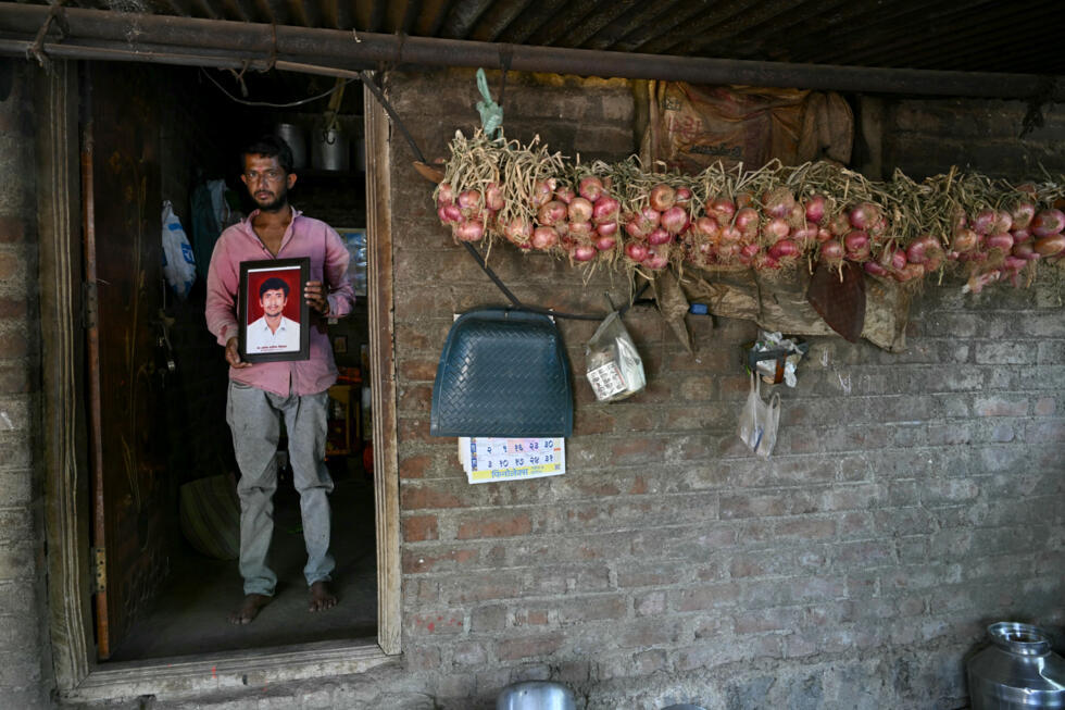 L'agriculteur Balaji Khindkar montre une photo de son frère d'Amol, qui s'est suicidé en raison de l'accumulation de prêts financiers, devant sa maison du village d'Ambilwadgaon, dans l'Etat du Maharashtra, le 3 mai 2025 en Inde