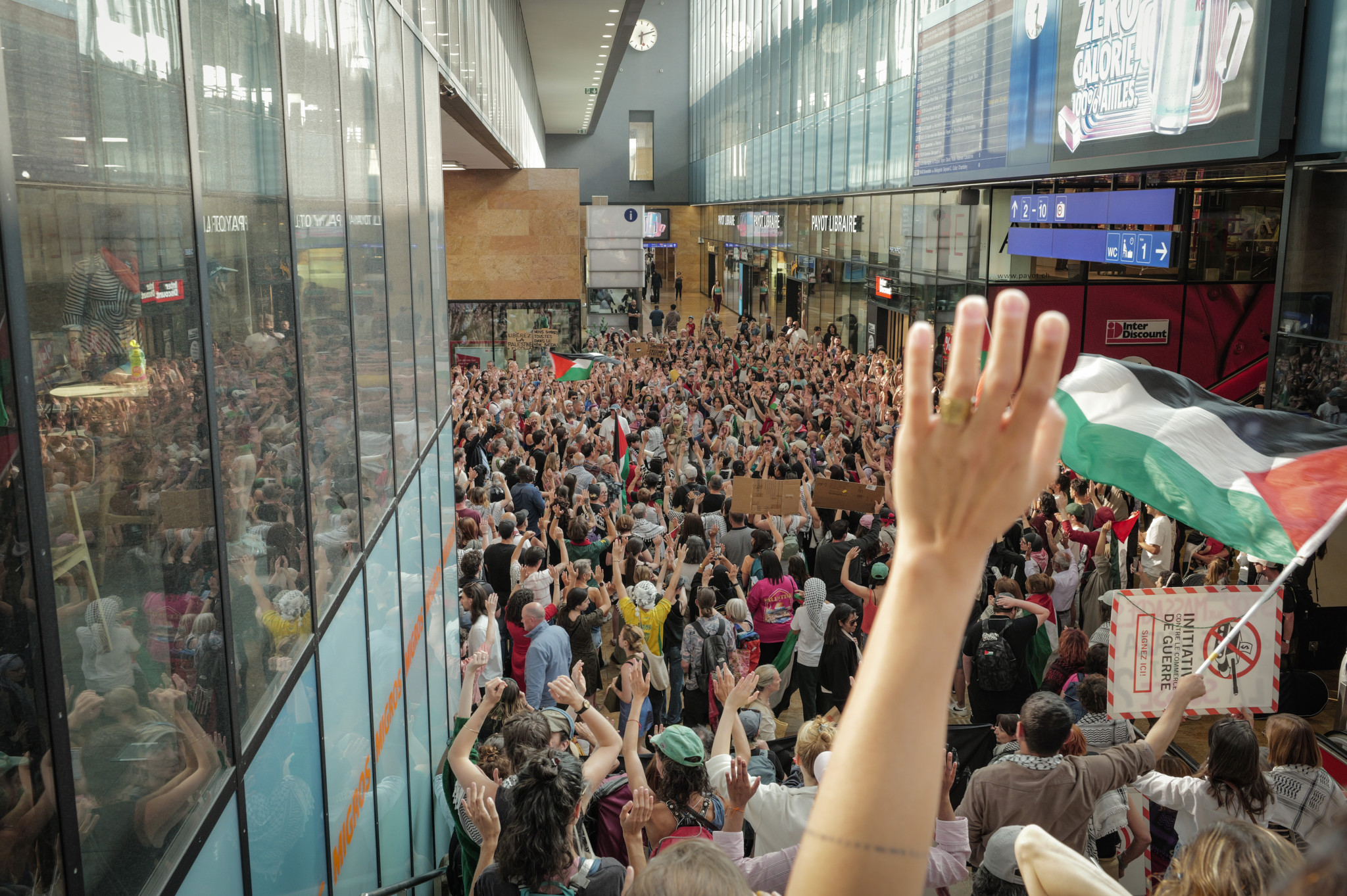 Manifestants à la gare Cornavin de Genève brandissant des drapeaux palestiniens contre la guerre à Gaza, le 9 juin 2025.