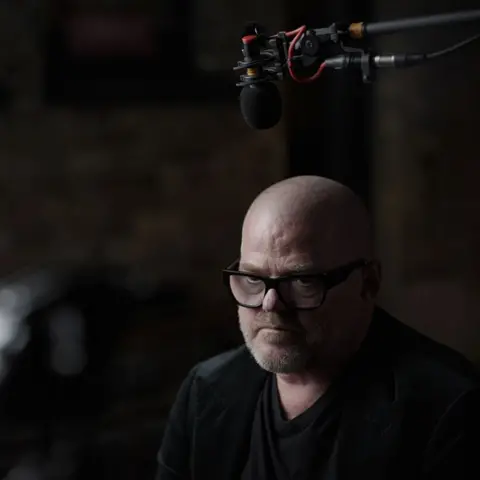 Heston Blumenthal pendant une interview, portant des lunettes à monture noire.