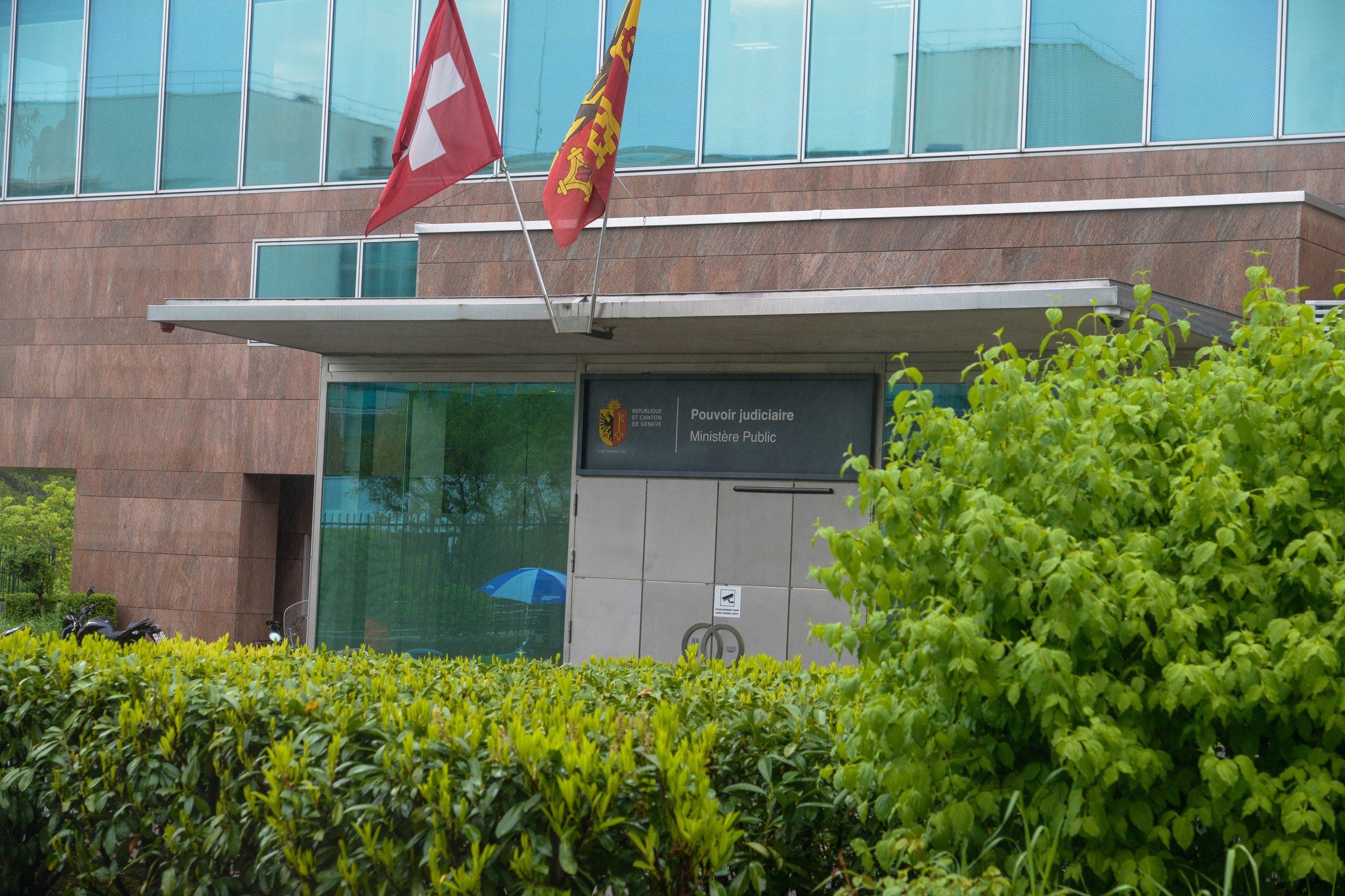 Entrée du Ministère public à Genève, avec les drapeaux suisse et cantonal.