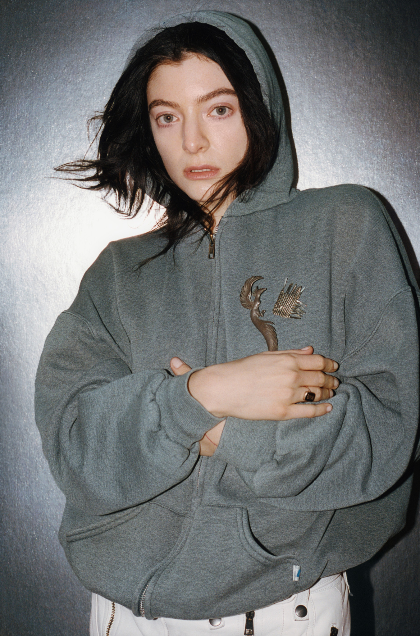Lorde portant un sweat à capuche gris