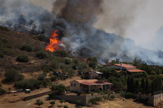 Flammes près des maisons lors de l'incendie à Thimari, Grèce, le 26 juin 2025.