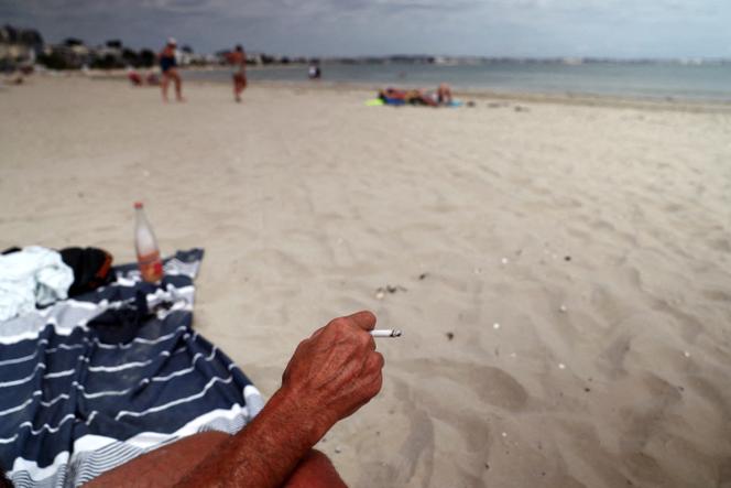 Un vacancier fume une cigarette sur la plage de La Baule (Loire-Atlantique), le 25 juin 2025.